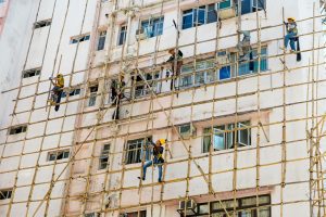 Window washers use scaffolding to scale the side of a building