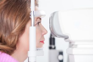 An optician examines a womans eye. 