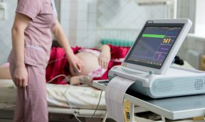 A midwife carries out a scan on a pregnant woman.