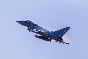 An RAF Typhoon jet flying in a clear sky.