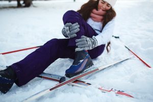 A woman holds her leg after a ski accident. 