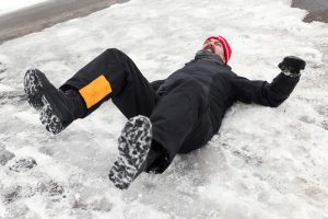 A man has slipped over on snow and ice. 