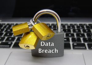 In front of a keyboard, a padlock says data breach. 