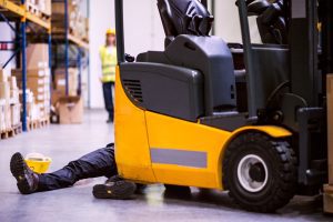 A person is injured in front of a lift truck vehicle. 