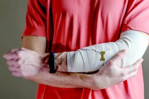 A man holds onto his injured arm. 