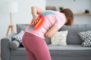 A woman is bent over in pain. A slipped disc injury is highlighted.