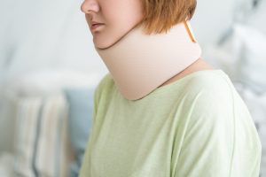 PERSON WEARING A BRACE BECAUSE OF A WHIPLASH INJURY IN A TAXI CAB