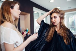 CLIENT DISCUSSING PROBLEM WITH HER HAIR WITH THE HAIRDRESSER