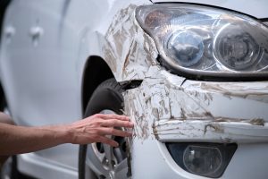 A parked car shows damage from a collision.