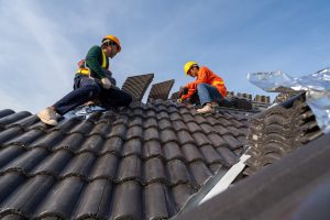 Two men work at height on a roof