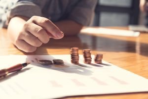 Mans hand counting coins due to financial hardship following a laser hair removal burn