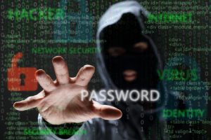 HOODED CYBER CRIMINAL REACHING FOR PASSWORD TO INDICATE DATA BREACH