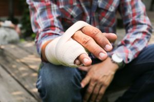 A person has their hand bandaged with a broken little finger and ring finger. 