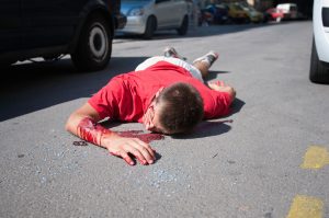 A man lying on the road after suffering from serious injuries after an accident with his e scooter