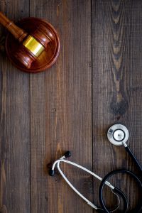 A gavel and stethoscope on a table. This represents a medical negligence claim which our solicitors represent for eligible clients on a No Win No Fee basis